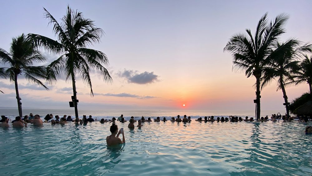 Infinity pool and palm trees facing the ocean in Seminyak